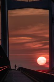 『女神大橋に落ちる夕日を眺める人』